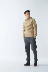 Buzo canguro color arena de felpa, con capucha ajustable, bolsillo tipo canguro, mangas largas y logo estampado en el pecho.