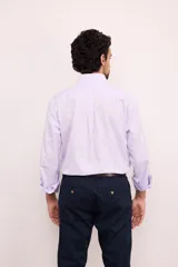 Camisa celeste con rayas verticales blancas, de corte clásico, con cuello abotonado, manga larga y bolsillo en el pecho.