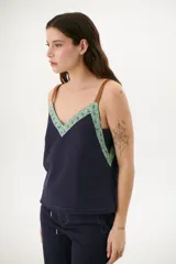 Musculosa azul con breteles finos color marrón y escote en V.