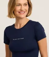 Remera deportiva azul marino de microfibra con cuello redondo, mangas cortas y estampa frontal con la frase "be your own muse".
