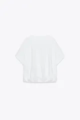 Camiseta blanca de algodón con cuello redondo, mangas cortas y bajo asimétrico ajustable con lazadas.