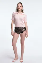 Top tejido de punto color lila con cuello polo y mangas cortas.