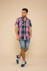 Camisa de manga corta con estampado a cuadros en tonos azul, rojo y blanco. Cierre con botones y tela ligera.