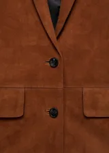 Chaqueta marrón de piel caprina con cuello de pico con solapa, diseño recto, cierre delantero con botones, forro interior, manga larga y dos bolsillos de solapa en la parte frontal.