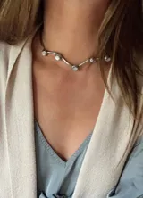 Gargantilla plateada con forma de V invertida, con apliques de nácar redondos.