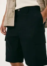 Bermuda de gabardina color verde con bolsillos laterales tipo cargo.