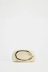 Bolso formato caja color crema con asa de cadena dorada para usar como bandolera. Cierre metálico dorado.