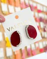 Aros colgantes de acrílico color borgoña con forma ovalada y borde superior con strass.
