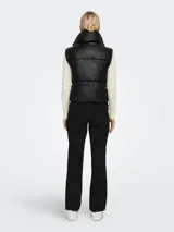 Chaleco puffer negro con cuello alto y cierre frontal con cremallera.