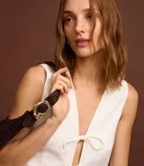 Chaleco blanco sin mangas con lazo delantero.