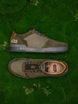 Zapatillas urbanas de cuero color verde oliva con detalles en marrón y negro. Presentan el logo de Star Wars en el talón y el rostro de Yoda grabado en el lateral.