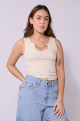 Musculosa color crema de corte ajustado, con cuello redondo y detalle de cadena dorada en el escote.
