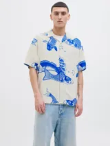Camisa de viscosa LENZING™ ECOVERO™ color blanco con estampado de peces koi azules, cuello resort, mangas cortas y corte relajado.
