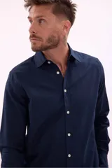 Camisa de manga larga color beige claro, de corte clásico y confeccionada en tejido texturizado.