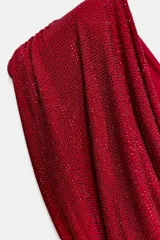 Vestido corto de fiesta color rojo con escote drapeado, mangas sisa con hombreras y detalle de strass combinados. Espalda con tiras cruzadas y cierre con cremallera metálica.