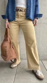 Pantalón de jean color beige, de corte recto y tiro alto, con bolsillos delanteros y traseros.