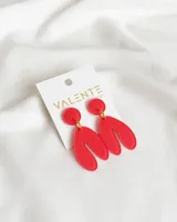 Aros colgantes de acrílico rojo con forma geométrica abstracta.