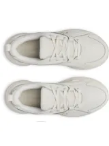 Zapatillas deportivas Under Armour modelo Assert 11 para mujer, color blanco hueso, con logo UA en el lateral. Presentan una suela gruesa con tecnología Charged+® y una combinación de malla transpirable y revestimientos de cuero sintético.