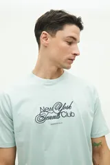 Remera de manga corta color verde agua con estampado de texto en el frente.