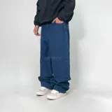 Pantalón de jean azul oscuro, corte ultra baggy, con bolsillos laterales y traseros.