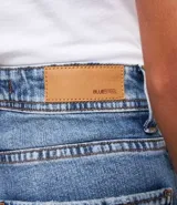 Pantalón mom jeans de tiro alto, color azul denim, con bolsillos y bajo plegado.