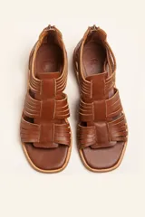 Sandalia de cuero color chocolate con tiras entrecruzadas y cierre trasero con cremallera.