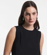 Blusa sin mangas color celeste, de crepé, con cuello redondo, pliegues en uno de los hombros y cierre trasero por cremallera con detalle de aro en el tirador.
