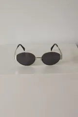 Lentes de sol con armazón metálica y protección UV400, de diseño redondo y lentes color marrón.