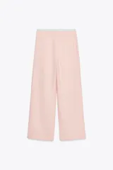 Pantalón de tiro alto color crema, con cintura combinada a contraste tipo boxer con cordones ajustables. Detalle de pinzas en delantero, bolsillos laterales y falso bolsillo de vivo en espalda.