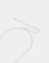 Collar plateado corto con cadena de eslabones y corazones. Dije principal de corazón con borde labrado y dije colgante de corazón calado.
