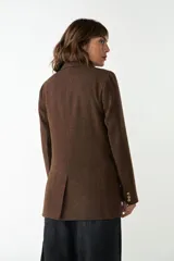 Blazer marrón de lana con solapas de muesca, cierre con dos botones dorados, bolsillos con solapa y forro interior a tono.