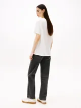 Remera blanca de corte relaxed con cuello redondo y logo Tommy Hilfiger gráfico estampado en el pecho.