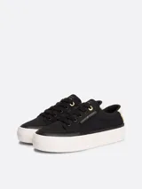 Zapatillas Tommy Hilfiger Essential de plataforma, color negro, confeccionadas en lona de algodón. Presentan suela de goma blanca, interior de poliéster, plantilla extraíble y logo metálico en la lengüeta y el lateral.