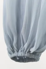 Pantalón celeste semitransparente de tiro medio con cintura elástica y tobillos abullonados con elástico.