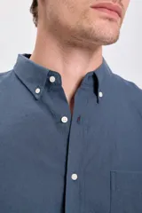 Camisa de lino azul oscuro de corte clásico, con cuello abotonado y bolsillo en el pecho.