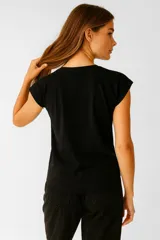 Remera color crema de algodón con estampado de un velero y la frase "Rough Waters Make The Best Sailors" en azul.