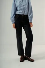 Pantalón de denim color negro lavado, de tiro medio y corte wide leg (pierna ancha y recta con caída fluida).