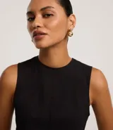 Vestido sin mangas, largo midi, color celeste claro, con escote redondo y corte evasé. Presenta breteles anchos y cierre trasero con cremallera.