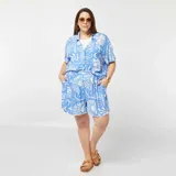 Conjunto de short y camisa celeste con estampado de soles, lunas, estrellas y texto en blanco. La camisa es de manga corta y el short tiene cintura elastizada.
