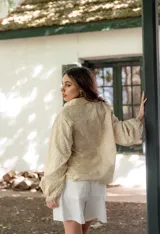 Camisa celeste con estampado de flores blancas, corte clásico, cuello camisero y mangas largas abullonadas.