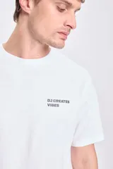 Camiseta blanca de corte oversize con estampa en la espalda con la frase "DJ Creates Vibes" y un disco de vinilo.