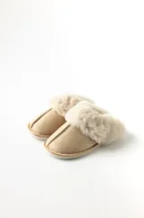 Pantuflas color beige con base de goma y borde superior de peluche.