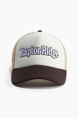 Gorra tipo trucker con visera curva color marrón, frente blanco con bordado de la marca "Raptor Ridge" en azul y blanco, y rejilla color beige.