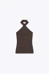 Top celeste de cuello halter y hombros descubiertos, con cierre de botones en la espalda.