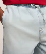 Bermuda baggy de jean celeste con cintura elástica y cordón ajustable.