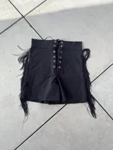 Short negro de bengalina elastizada con cintura alta, cordones cruzados en el frente y flecos en los laterales.