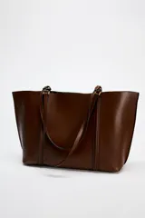 Bolso negro tipo shopper con asa de hombro, detalle de colgador y bolsillo interior maxi. Cierre mediante imán.