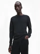 Sweater gris oscuro de lana merino 100% certificada, con cuello redondo y logo de Calvin Klein bordado en el pecho.