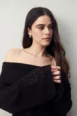 Sweater color crema, tejido de punto calado, con escote off-shoulder y mangas largas acampanadas.