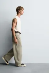 Pantalón de jean blanco, corte holgado y amplio en toda la pierna, tiro medio, tejido ligero, cinco bolsillos, efecto lavado y cierre frontal con cremallera y botón.